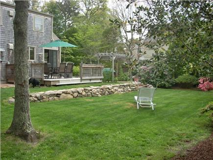 Harwich Center Cape Cod vacation rental - backyard deck, table, chairs, umbr. outdoor shower, nice yard