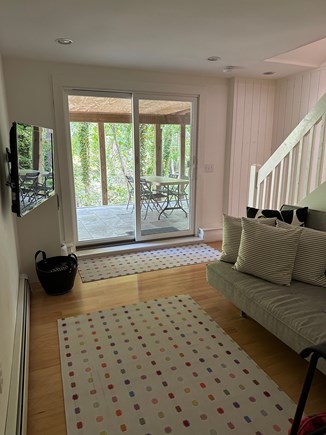 Wellfleet Cape Cod vacation rental - TV area with slider onto wooded patio