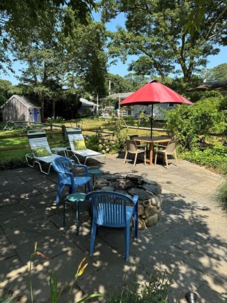 Long Pond, Harwich Cape Cod vacation rental - Corner patio with various seating options and a fire pit!
