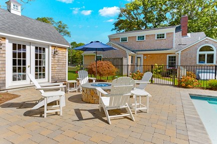 Brewster Cape Cod vacation rental - View of the fire pit, cabana and back of the house.