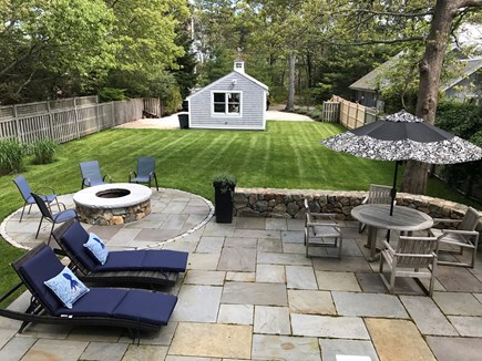 Seconsett Island, Mashpee Cape Cod vacation rental - Bluestone Patio with table, loungers, stonewall and fire pit