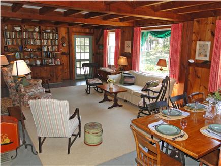 East Orleans Cape Cod vacation rental - Living room with woodwork, windows facing the water, door to deck