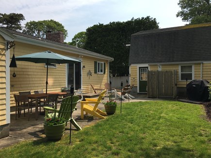 N FALMOUTH Cape Cod vacation rental - Patio area: table for 8, umbrella, gas grill, adirondack chairs.