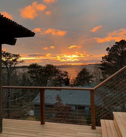 Wellfleet Cape Cod vacation rental - Part of back deck at sunset. Dining table and chaises to enjoy.