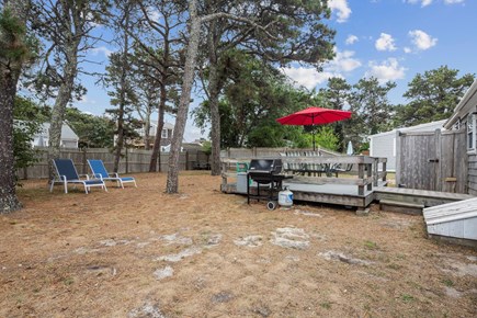 Dennis Port Cape Cod vacation rental - Back deck with propane grill and Cape Cod lawn