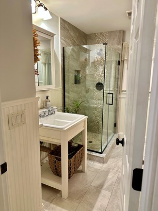 Eastham Cape Cod vacation rental - Updated bathroom with stacked washer/dryer behind barndoors.