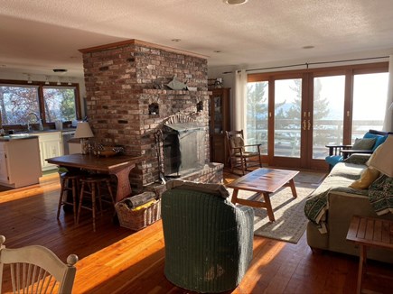 Truro Cape Cod vacation rental - Open livingroom kitchen. Fireplace in the middle with waterviews.