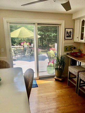 Cotuit /Mashpee line south of  Cape Cod vacation rental - slider to Sunny deck ; cascading flowers, fire table, shower