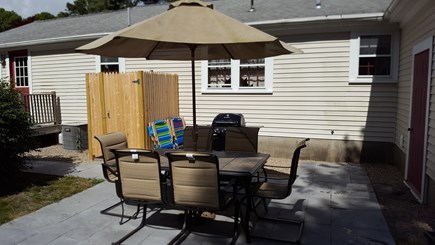 South Dennis Cape Cod vacation rental - Patio with outdoor shower, grill, and beach chairs.