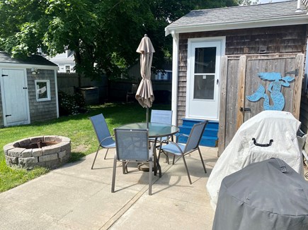 West Yarmouth Cape Cod vacation rental - Backyard with outdoor dining, fire pit, and outdoor shower