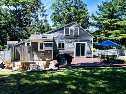 Harwich Cape Cod vacation rental - Large deck, table with 6 chairs, grill, tv fire pit and shower.