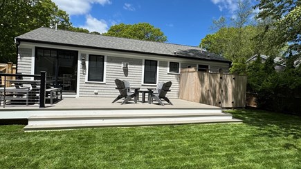 Popponesset Cape Cod vacation rental - Private fenced back yard with deck, fire pit, 2 shrws, and TV
