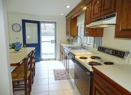 Harwich Port Cape Cod vacation rental - Kitchen leading to side yard with gas grill