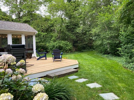North Eastham Cape Cod vacation rental - Backyard deck and screened porch. Stone path to outdoor shower.