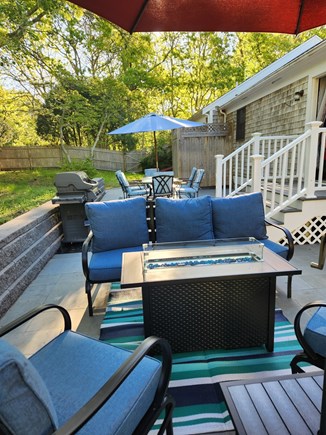 Harwich Cape Cod vacation rental - New back patio in 2025 with seating, firepit, and propane grill