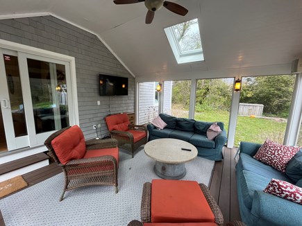 Harwichport Cape Cod vacation rental - Screen Porch with view to back yard, fire pit and outdoor shower