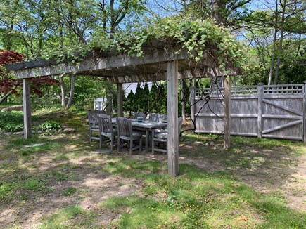 Brewster Cape Cod vacation rental - Large backyard with grapevine covered pergola and outdoor dining!