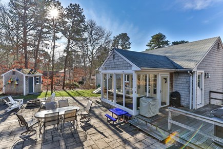 Dennis Cape Cod vacation rental - Backyard with grill, dining table, and fire pit.