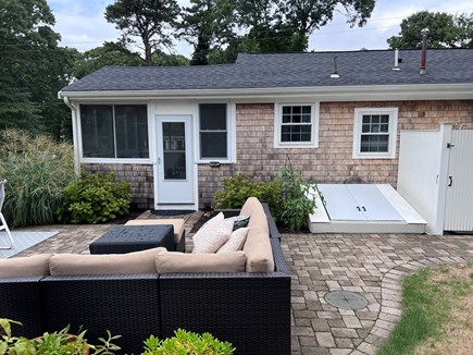 North Falmouth Cape Cod vacation rental - Rear of house porch entry, seating, bulkhead, outside shower