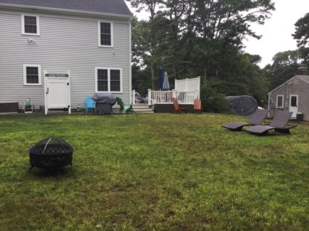 Dennis Cape Cod vacation rental - Backyard with outdoor shower, fire pit, grill and cozy’s seating.