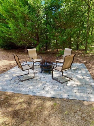 Brewster Cape Cod vacation rental - Fire pit area with 4 chairs. Outdoor lights surround the backyard