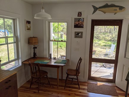 Orleans Cape Cod vacation rental - Rustic pine dining table and screen door to farmers porch.