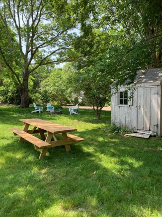 Brewster Cape Cod vacation rental - Backyard with shed, picnic table, fire pit, and Adirondacks