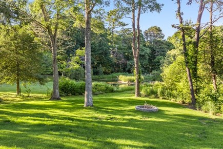 Osterville Cape Cod vacation rental - Large backyard with fire pit overlooking the pond