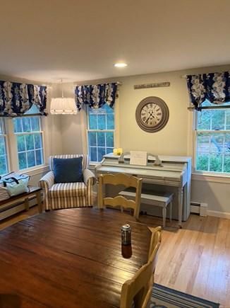 Eastham Cape Cod vacation rental - Dining table at Georgia's with cozy club chair and piano far end.