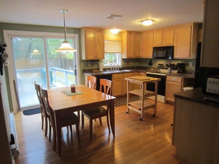 South Yarmouth Cape Cod vacation rental - Open kitchen & dining area with sliders to three season room
