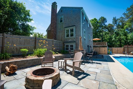 Harwich Cape Cod vacation rental - New firepit and Adirondack chairs adjacent to in-ground pool.
