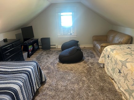 Falmouth Center Cape Cod vacation rental - Upstairs bedroom with queen and twin beds, tv and love seat.
