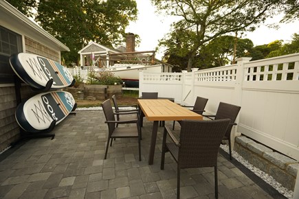 Dennis Cape Cod vacation rental - 2nd sideyard patio has a dinning table, chairs and paddleboards