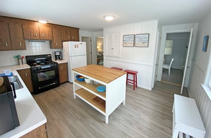 South Dennis Cape Cod vacation rental - The kitchen has a central island with stools for gathering.