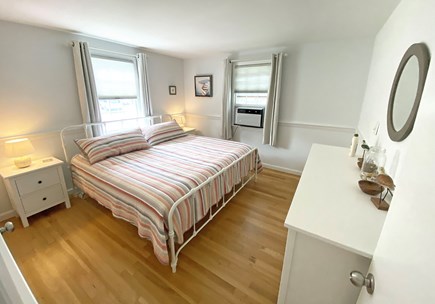 Dennis Cape Cod vacation rental - King bedroom has warm light, a new mattress and clothes storage.