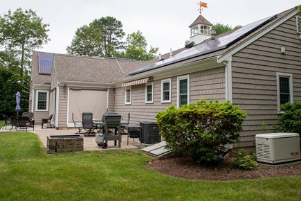 Hyannis Cape Cod vacation rental - Patio showing gas grill and fire pit, table, awning