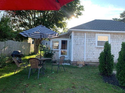 Dennis Port Cape Cod vacation rental - Side view of outdoor dining, gas grill and gas firepit.