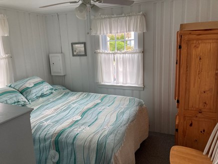 South Yarmouth Cape Cod vacation rental - Airy bedroom with queen bed, window air conditioner and fan.