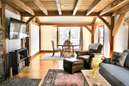 North Falmouth Cape Cod vacation rental - Open living room + dining room with mounted tv and games.