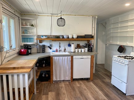 Eastham Cape Cod vacation rental - Kitchen with open shelves, gas stove, and dishwasher