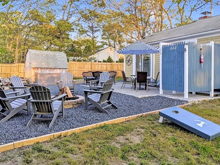 South Dennis Cape Cod vacation rental - Backyard w/ outdoor shower, fire pit, patio, and gas grill.