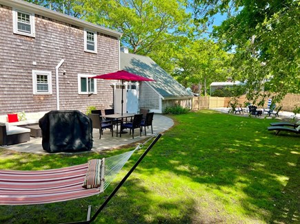 West Yarmouth Cape Cod vacation rental - Fenced backyard with dining table for 6, patio furniture, hammock