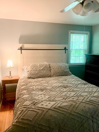 Dennis Cape Cod vacation rental - Primary bed with dresser, half bath and laundry room.