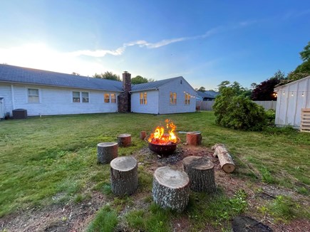 Centerville Cape Cod vacation rental - Fire pit and backyard with the main house.