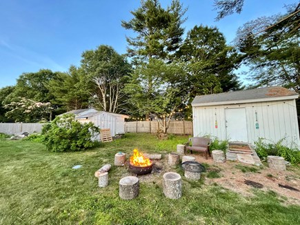 Centerville Cape Cod vacation rental - Fire pit and backyard with the 3 sheds.