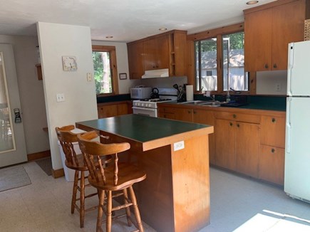 Eastham Cape Cod vacation rental - Kitchen view with island and dining overlooking the deck