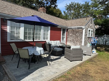 Harwich Port Cape Cod vacation rental - Patio with dining table, outdoor seating with fire pit table.