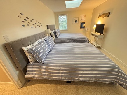 Harwich Cape Cod vacation rental - Upstairs bedroom with queen beds, skylight, and smart TV