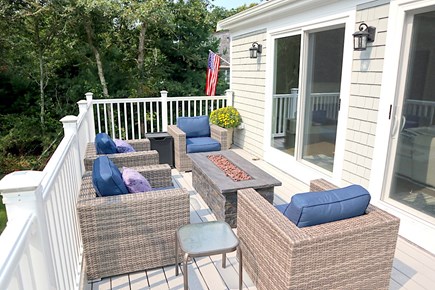 Harwich Cape Cod vacation rental - Charming deck area off the family room with a fire table