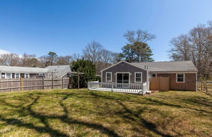 South Yarmouth Cape Cod vacation rental - Backyard with deck (outdoor patio set and firepit not shown)